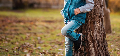 teenager leaning against tree